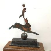 A naive American folk art style fox and hare, the cut copper animals on a central stem with a ball