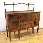 An Edwardian mahogany canted front sideboard, in the Cotswolds style, the raised gallery back