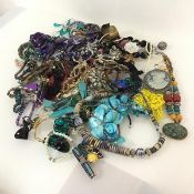 A large assortment of costume jewellery including a coloured shell necklace, paste and glass
