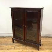 A Stag side cabinet, the rectangular top with moulded edge over a pair of glazed doors, with two