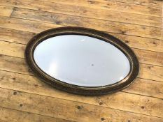 An Edwardian partial gilt framed wall mirror, the bevelled plate within a moulded border with