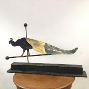 A naive art sculpture in the form of a painted metal peacock wind vane (57cm x 89cm x 24cm)