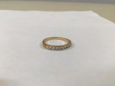 A yellow metal channel set half eternity ring with brilliant cut diamonds (2.65g) (S)