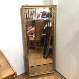 A three panel wall mirror, with central bevelled glass flanked by two smaller bevelled panels,