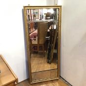 A three panel wall mirror, with central bevelled glass flanked by two smaller bevelled panels,