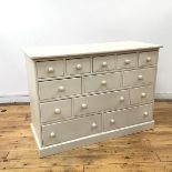 A white painted pine chest of drawers, the rectangular top above thirteen drawers, raised on a