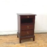 A modern mahogany bedside table, the rectangular top with moulded edge over a frieze slide above a