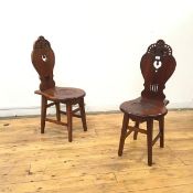 A pair of 19thc style mahogany hall chairs, each with cartouche shaped back embellished with pierced