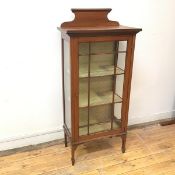 An Edwardian mahogany display cabinet with hinged door and glass to sides, with two shelves to