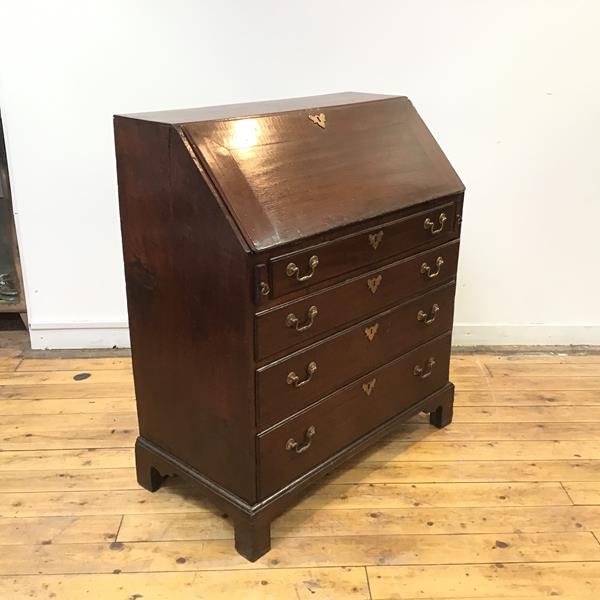 A George III oak fall front bureau, the hinged top enclosing a fitted interior with drawers,