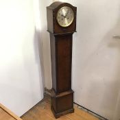 A 1920s oak standing hall clock, the domed top above a circular dial with arabic numerals, flanked