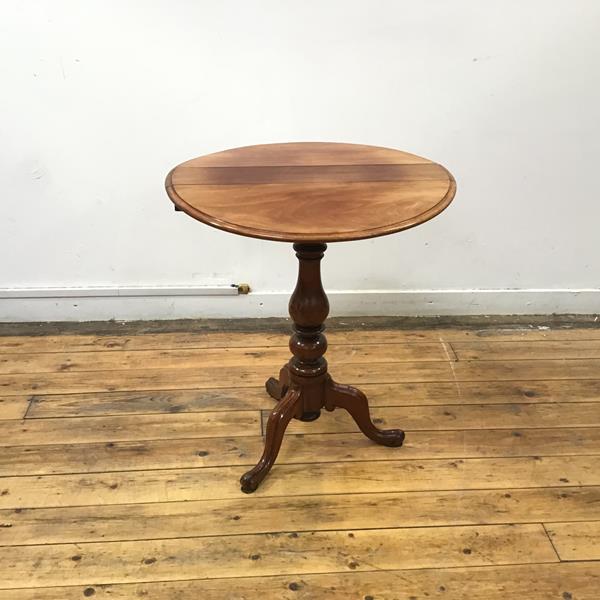 A mid 19thc mahogany wine table, the circular hinged top with moulded edge on a baluster shaft and