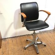 A modern adjustable height office chair with black leather padded back and seat, with foot