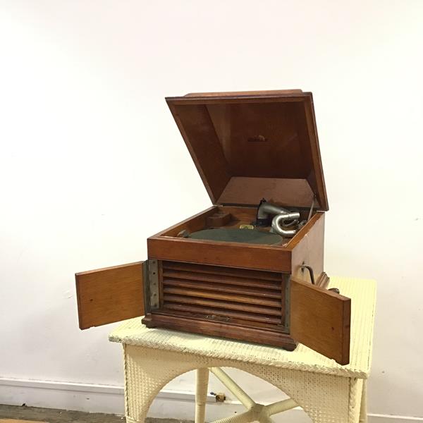 An HMV oak cased wind up gramophone, the moulded hinged lid opening with HMV logo to base, record