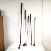 A collection of golf clubs, including one imitation treen club of early design (l.127cm), a