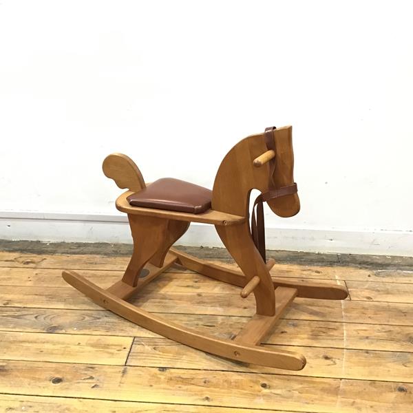 A Moulin Roty rocking horse, having padded seat and leather reins, with stamp to rear stretcher (