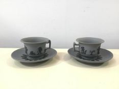 A pair of early 19thc sprigged cups and saucers, each cup decorated with black sprigged draped putti