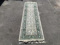 A hand knotted wool runner, made in North Africa, the ivory field allover decorated with