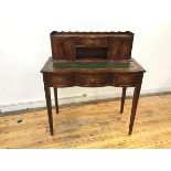 A reproduction mahogany writing table, the attached superstructure with scalloped gallery and