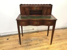 A reproduction mahogany writing table, the attached superstructure with scalloped gallery and