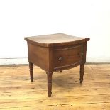 A Regency mahogany commode, the hinged bow fronted top above a false drawer, on turned tapering legs