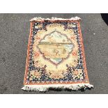 A North West Persian hand knotted pictoral rug, the central cartouche depicting deer and a goat by a