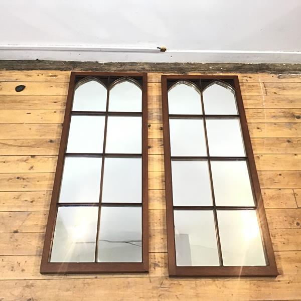 A pair of mahogany framed wall mirrors, each with arched top and eight divisions below, formerly