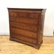 A reproduction cherrywood chest, the undulating frieze above an arrangement of short and long