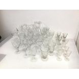 An assortment of stemware including crystal and glass wine glasses, sherry glasses, liqueur