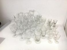 An assortment of stemware including crystal and glass wine glasses, sherry glasses, liqueur