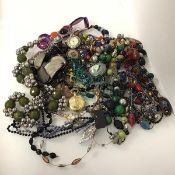 A large assortment of costume jewellery including paste and glass beads, pocket watches,