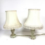 A pair of bedside lamps with onyx baluster shaped bases complete with fringed lampshades (h.40cm x