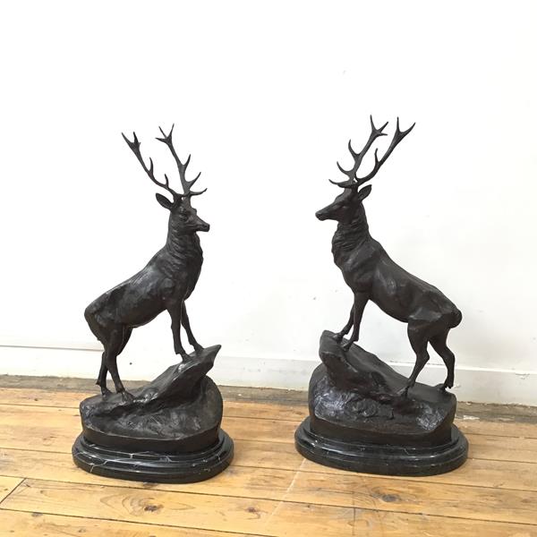 A large pair of bronze stags, both standing on rocky outcrop and signed J.Moigniez, on moulded