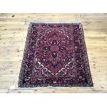 A Hamadan rug, the madder field with stylised floral medallion within ivory and blue spandrels and