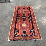 A hand knotted wool carpet of Caucasian design, the indigo field with two large medallions framed in