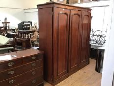 A Victorian mahogany triple wardrobe, the projecting cornice above one enclosing open hanging