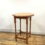 An oak occasional table, the circular scalloped top on square frame with barley twist supports,