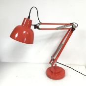 An anglepoise style lamp with domed shade and a two tier circular base in coral pink (h.76cm x d.