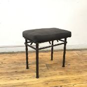 A modern patinated metal dressing stool, the detachable cushion seat on undulating legs