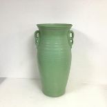 A mottled mint green standing vase, the flared rim above a baluster shaped ribbed body, with two