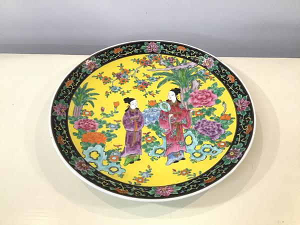 A large Chinese famille jaune dish showing two Ladies in a Garden (d.37cm)