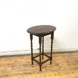 A 1930s oak occasional table, the oval moulded top on barley turned supports (76cm x 60cm x 44cm)