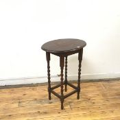 A 1930s oak occasional table, the oval moulded top on barley turned supports (76cm x 60cm x 44cm)