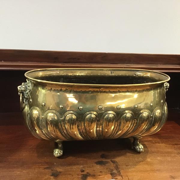 A late 19thc brass planter, of oval form, with lion mask handles and gadroon body, one loop handle