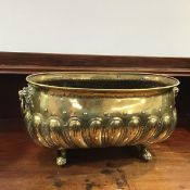 A late 19thc brass planter, of oval form, with lion mask handles and gadroon body, one loop handle