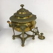A brass samovar, the domed lid above a bulbous body with scrolling handles connected by turned bone,