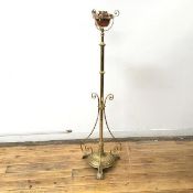 An Edwardian brass floor standing lamp with copper burner, the stem with three ribbon supports