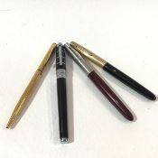 A group of pens including a Parker gold plated ball point pen with engine turned case, a Parker