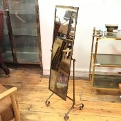A wrought iron framed cheval style miniature mirror, raised on adjustable scroll stand (113cm x 33cm