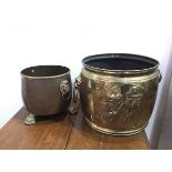 An Edwardian brass jardiniere/bucket, with lion mask handles to sides and two Gentleman in hats in